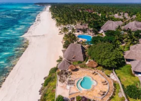 Spettacolare panoramica dall'alto del Karafuu Beach Resort con le piscine rotonde sul bagnasciuga, i tetti in makuti e la lunghissima costa di Zanzibar