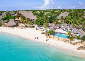 Spettacolare veduta aerea panoramica del My Blue Hotel Zanzibar con la piscina sul bagnasciuga, le strutture in makuti e la spiaggia bagnata dal mare turchese