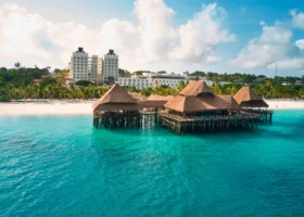 Una struttura in legno con tetti in paglia costruita su palafitte sopra l'oceano turchese di fronte alla spiaggia dell'Hotel Riu Jambo