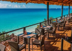 Tavoli in vimini disposti sulla terrazza coperta in paglia del bar del Royal Zanzibar Beach Resort con vista panoramica sull'oceano turchese