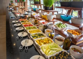 Una lunga linea di buffet del Royal Zanzibar Beach Resort ricca di ciotole colorate con verdure fresche, olive e condimenti