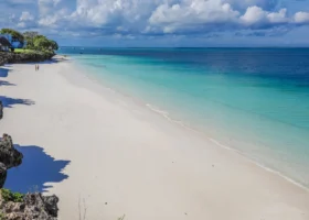 La bianca barriera di sabbia del Royal Zanzibar Beach Resort costeggiata da rocce scure e bagnata dalle sfumature turchesi dell'oceano