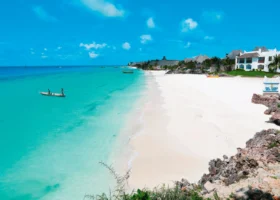 Veduta dall'alto della spiaggia candida del Royal Zanzibar Beach Resort con una piccola imbarcazione che naviga nell'acqua cristallina
