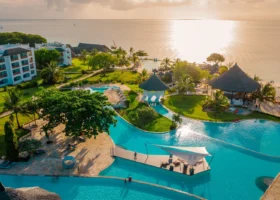 Foto aerea dei lussureggianti giardini e delle ampie piscine del Royal Zanzibar Beach Resort illuminate dai caldi riflessi del sole calante