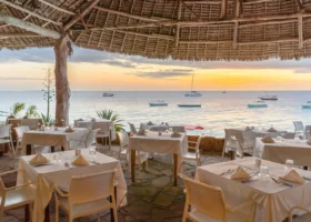 Tavoli apparecchiati del ristorante all'aperto vista mare del Sandies Baobab Beach Resort a Zanzibar