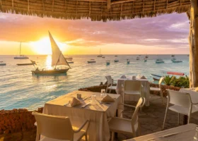 Spettacolare vista del tramonto sull'oceano con barca a vela tradizionale dal ristorante del Sandies Baobab Beach Resort